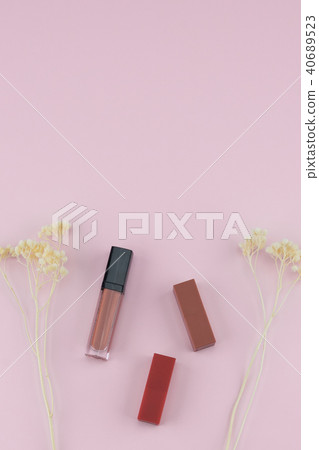 Lipsticks and lip gloss with white dried flowers Lipsticks and lip gloss with white dried flowers 40689523