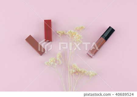 Lipsticks and lip gloss with white dried flowers Lipsticks and lip gloss with white dried flowers 40689524