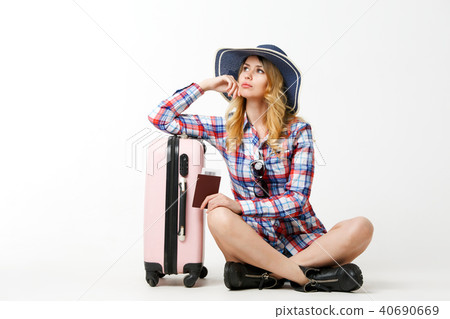 Image of blonde in hat with passport sitting near suitcase Image of blonde in hat with passport sitting near suitcase 40690669