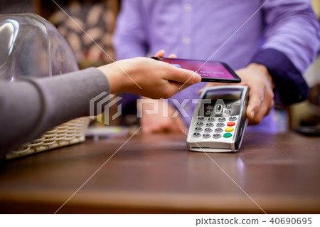 Picture of seller with terminal and buyer with smartphone Picture of seller with terminal and buyer with smartphone 40690695