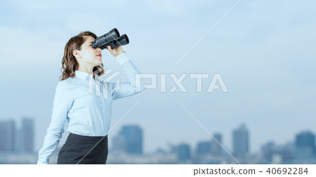 Business woman with binoculars 40692284