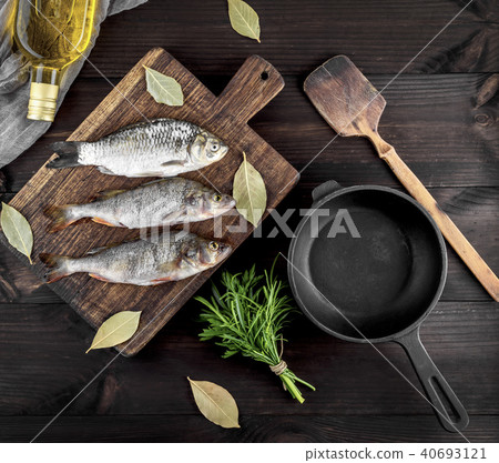 three river fish on a brown wooden board three river fish on a brown wooden board 40693121