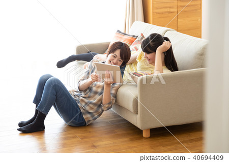 Parents and children watching tablet on the sofa 40694409