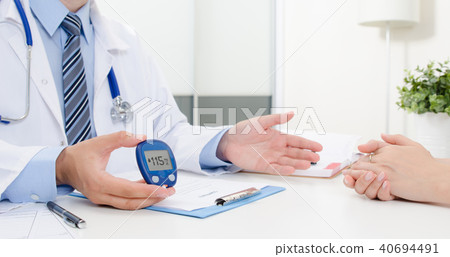 Doctor shows glucometer with glucose level Doctor shows glucometer with glucose level 40694491