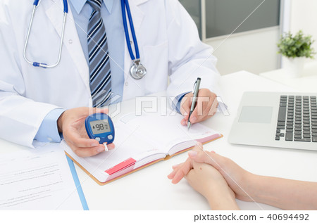 Doctor shows glucometer with glucose level Doctor shows glucometer with glucose level 40694492