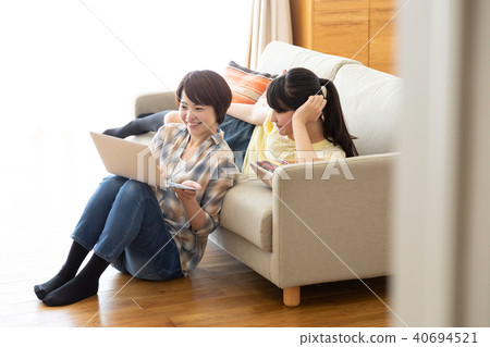 Parent and child looking at laptop on sofa 40694521