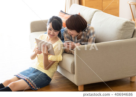 觀看在沙發的父母和孩子片劑 40694686