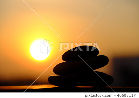 stack of pebble on yellow sun background stack of pebble on yellow sun background 40695117
