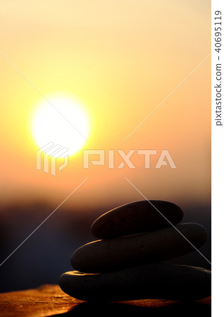 stack of pebble on yellow sun background stack of pebble on yellow sun background 40695119