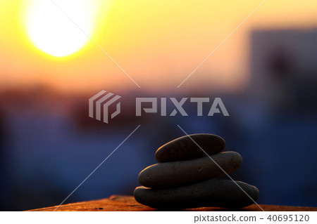 stack of pebble on yellow sun background stack of pebble on yellow sun background 40695120
