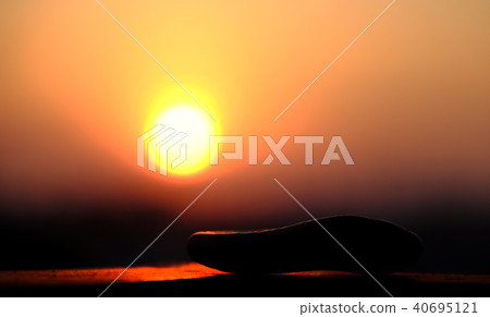 stack of pebble on yellow sun background 40695121