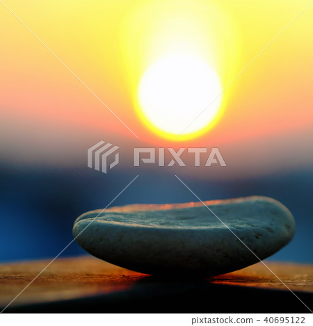 stack of pebble on yellow sun background stack of pebble on yellow sun background 40695122