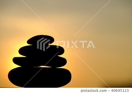 stack of pebble on yellow sun background stack of pebble on yellow sun background 40695123