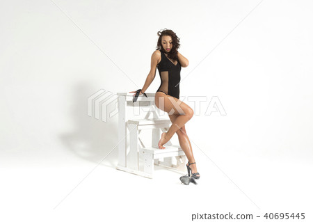 Beautiful young sexy girl posing on stairs in studio in sexy underwear, with curly hair and sports 40695445