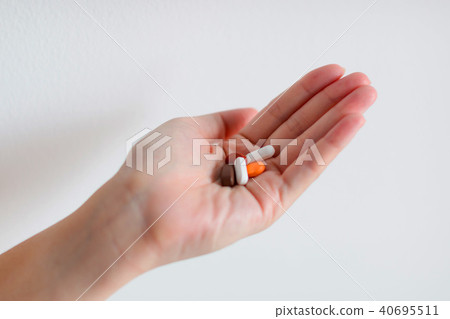 A hand is holding tablet medicines. 40695511