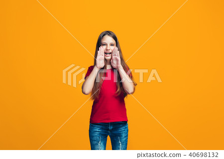 Isolated on yellow young casual teen girl shouting at studio 40698132