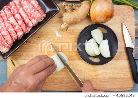 Chef cutting onion before cooking 40698148