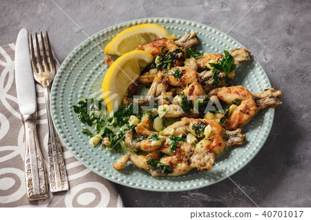 Frog legs baked with garlic butter and parsley. Frog legs baked with garlic butter and parsley. 40701017
