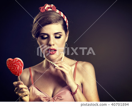 Woman eating lollipops. Girl in pin-up style hold striped candy. 40701894