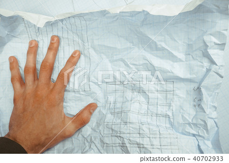 hand crumples the paper over the table 40702933