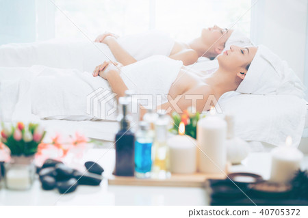 Relaxed young woman lying on spa bed for massage. Relaxed young woman lying on spa bed for massage. 40705372