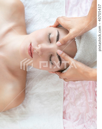 Woman gets facial and head massage in luxury spa. Woman gets facial and head massage in luxury spa. 40705437
