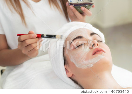 Beautiful woman having a facial treatment at spa. Beautiful woman having a facial treatment at spa. 40705440