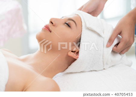Relaxed young woman lying on spa bed for massage. Relaxed young woman lying on spa bed for massage. 40705453