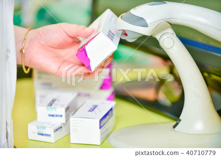 Pharmacist scanning barcode of medicine drug 40710779