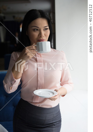Portrait of businesswoman having coffee 40712512