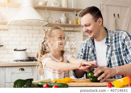 Little girl and dad having fun while cooking in kitchen 40714641