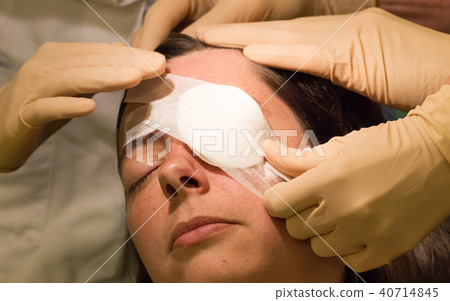 Doctor covering eye of patient by medical plaster 40714845