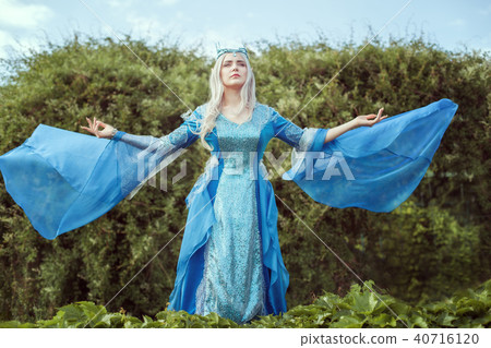 Young woman elf stands in the forest and looking up. 40716120