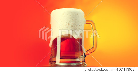 Beer mug with froth over yellow background Beer mug with froth over yellow background 40717803