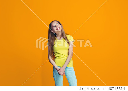The happy teen girl standing and smiling against pink background. The happy teen girl standing and smiling against pink background. 40717814