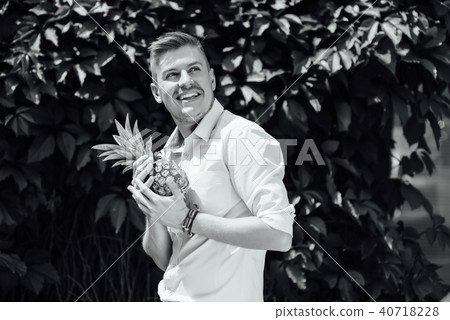 cheerful emotional guy holding a pineapple. cheerful emotional guy holding a pineapple. 40718228