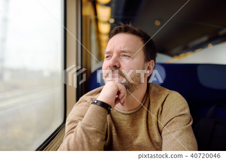 Middle age man looking out of the window of train Middle age man looking out of the window of train 40720046