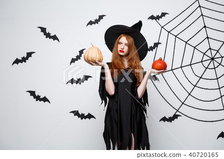 Portrait of beautiful caucasian witch holding pumpkin for celebrating Halloween. Portrait of beautiful caucasian witch holding pumpkin for celebrating Halloween. 40720165