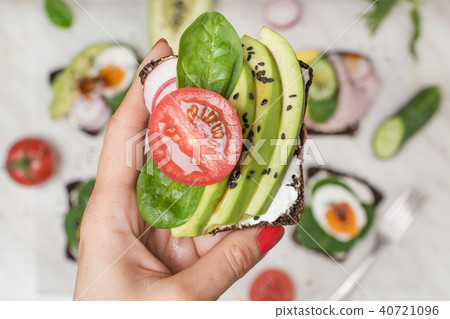 One sandwichin female hand.Summer snack,superfood. One sandwichin female hand.Summer snack,superfood. 40721096