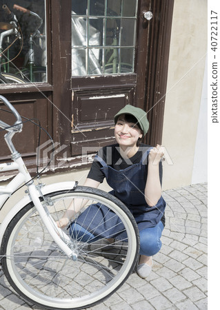 Young woman doing bicycle maintenance 40722117