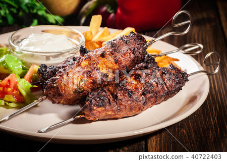 Grilled shish kebab served with fried chips 40722403