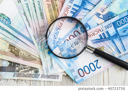 Hand lens on a bundle of russian large notes 40723738