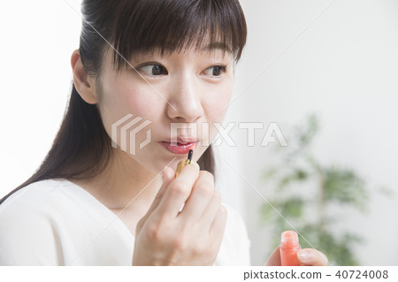 A woman applying lipstick A woman applying lipstick 40724008