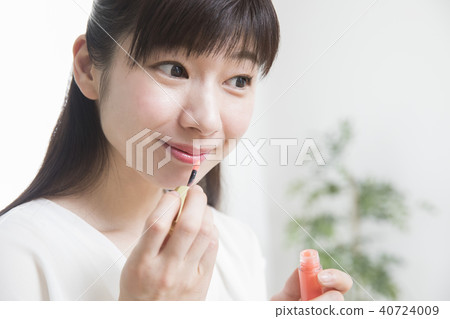 A woman applying lipstick A woman applying lipstick 40724009