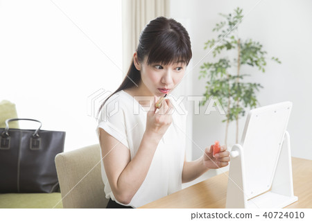 A woman applying lipstick A woman applying lipstick 40724010