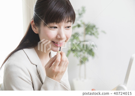 A woman applying lipstick A woman applying lipstick 40724015
