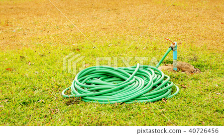 Tap and rubber tube on a grass. Tap and rubber tube on a grass. 40726456