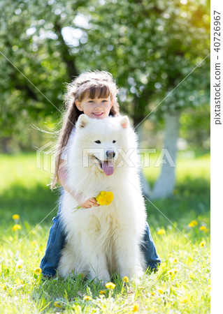 Little girl with a big white dog in the park. Little girl with a big white dog in the park. 40726967