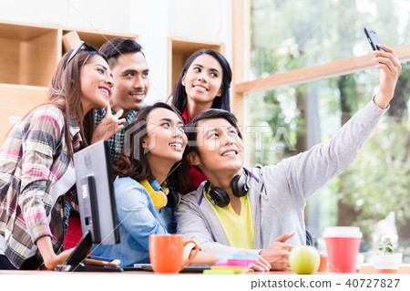 Creative team of five enthusiastic employees making a selfie photo Creative team of five enthusiastic employees making a selfie photo 40727827