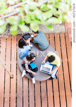 Young employees using modern wireless technology while working outdoors Young employees using modern wireless technology while working outdoors 40727828